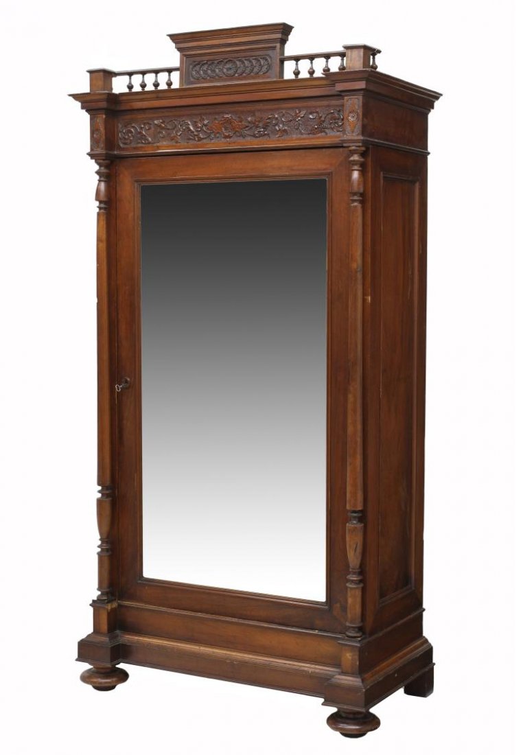 FRENCH RENAISSANCE REVIVAL MIRRORED ARMOIRE: French Renaissance Revival armoire, c. 1900, carved and spindle cornice above the single beveled mirrored door with flanking columns, the interior with a lower door, rising on bun feet, 86.5"h, 43.75"