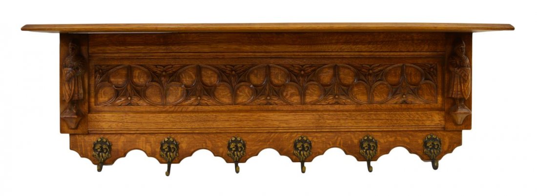 FRENCH GOTHIC REVIVAL COAT RACK: French Gothic Revival coat rack, late 19th c., oak with an upper shelf over the tracery carved central panel flanked at each side by knights with shields, six lower metal coat hooks, 16.25"h, 47.75"w,