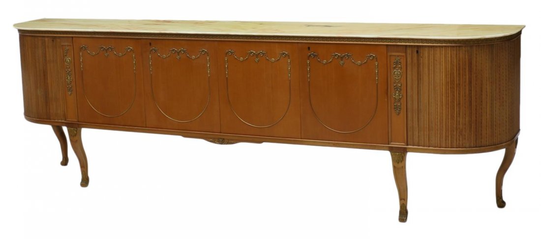 ITALIAN DESIGN LONG MARBLE TOP SIDEBOARD, C. 1940: Italian design marble top sideboard, c. 1940, the long case of D form, cabinet doors with foliated gilt metal mountings rise on gently curved legs, ending in a capped gilt metal scrolled toe, approx 3