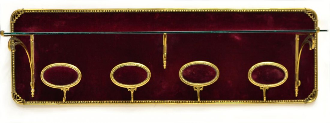 ITALIAN HANGING COAT & HAT RACK: Italian hanging coat and hat rack, c. 1950, gilt metal frame with padded red velvet back set with four hooks and glass shelf, some thinning to fabric and roughness to glass edges, approx 13.25"h, 42.2