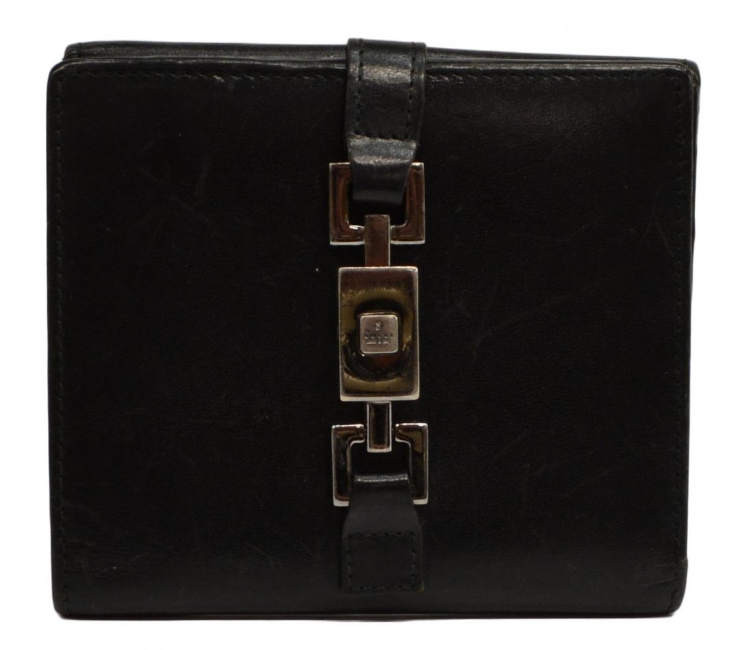 GUCCI BLACK LEATHER & SILVER TONE METAL WALLET: Gucci square wallet in black leather with silver toned hardware, interior having card slots and two open cell pockets, exterior having flap closure coin pocket, silver stoned piston closure, wear to l