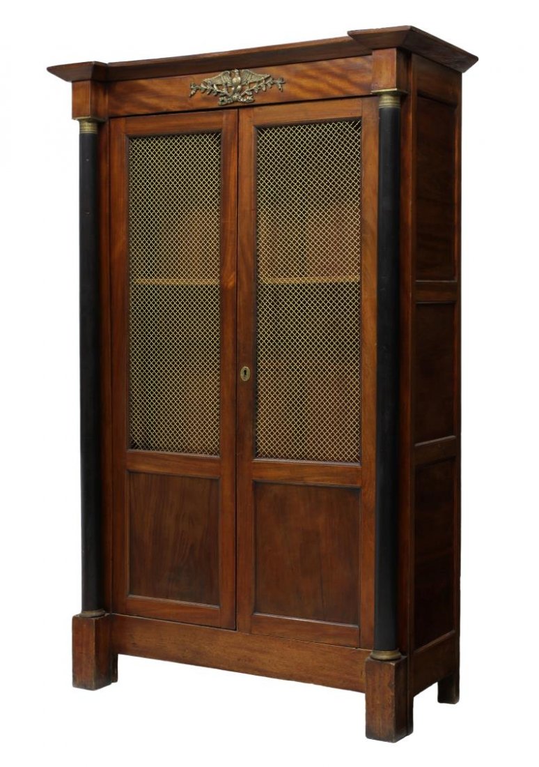 FRENCH EMPIRE STYLE CABINET: French Empire style cabinet, 20th c., having a protruding cornice, a gilt brass eagle decorated frieze over two doors with upper gilt screen panels, flanking gilt accented ebonized columns, rising on 
