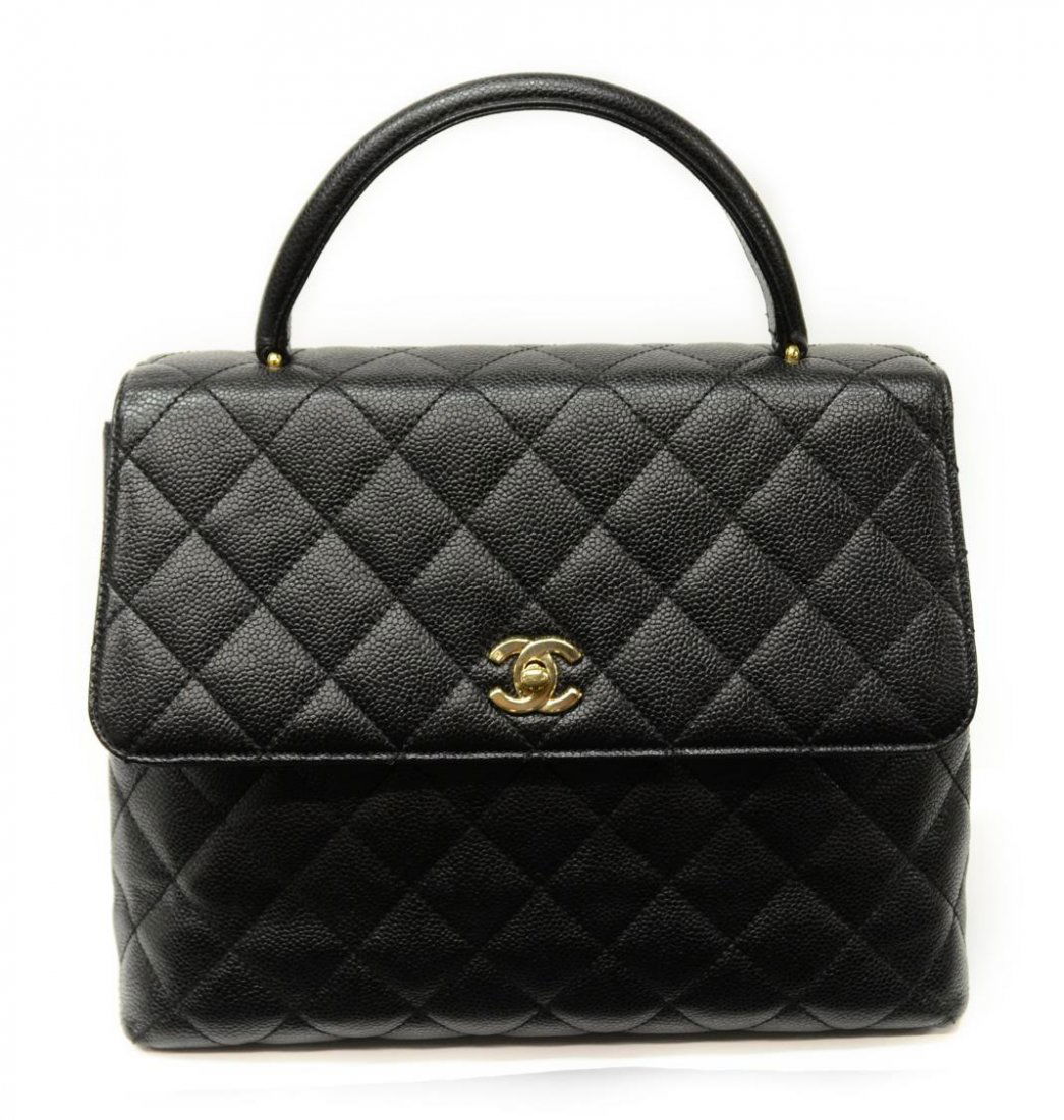 CHANEL KELLY BLACK QUILTED LEATHER HANDBAG: Chanel "Kelly" flap top hand bag in black grain leather with gold tone hardware, black leather interior with one side zipper pocket and open cell pocket, CC logo turnlock closure, single leather handl