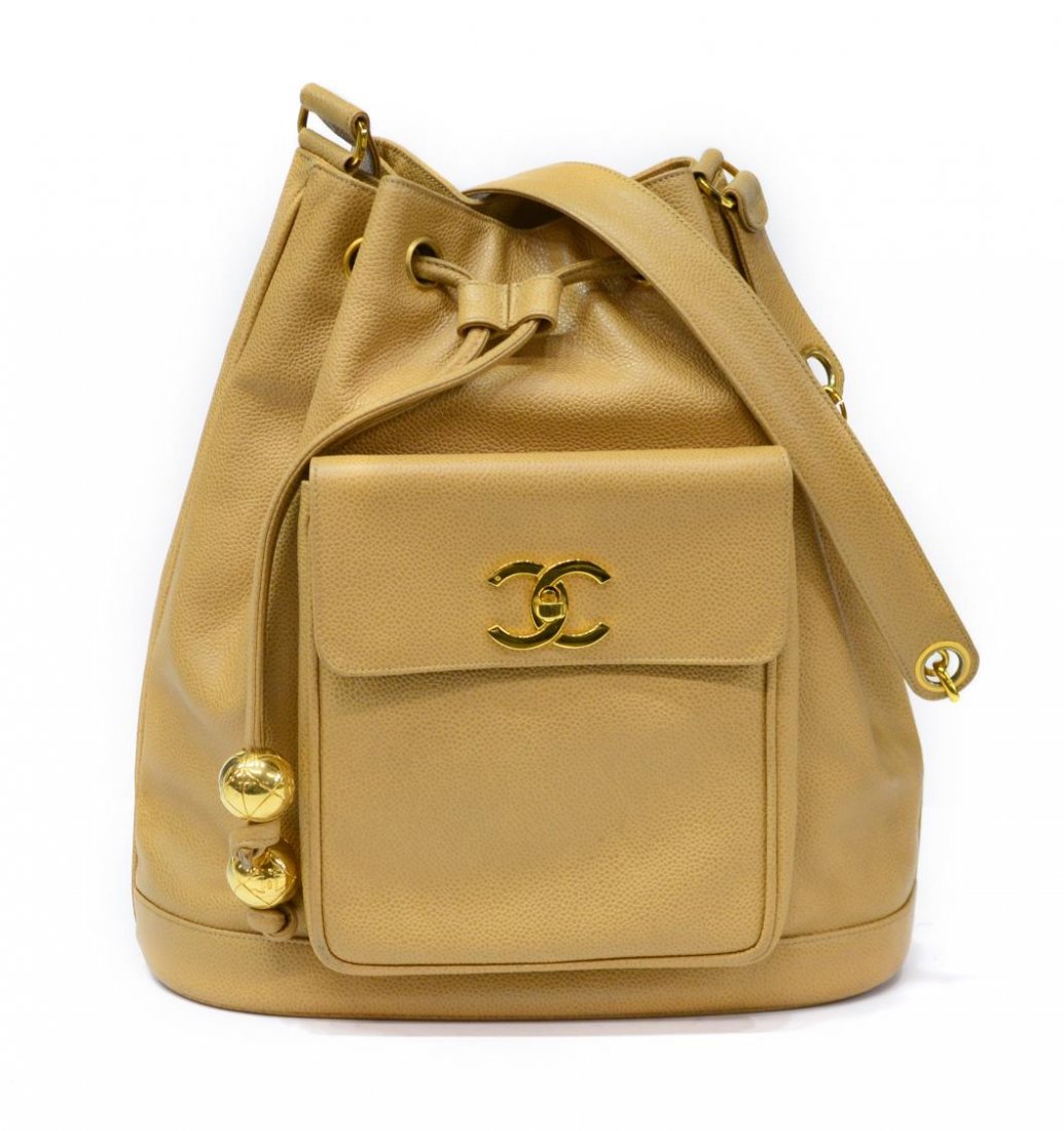 CHANEL TAN GRAIN LEATHER & GILT METAL BACKPACK: Chanel back pack in tan grain leather and gold tone hardware, beige leather interior with draw string tie closure, exterior having CC logo turn lock pocket, accompanied by small pouch, authenticated,