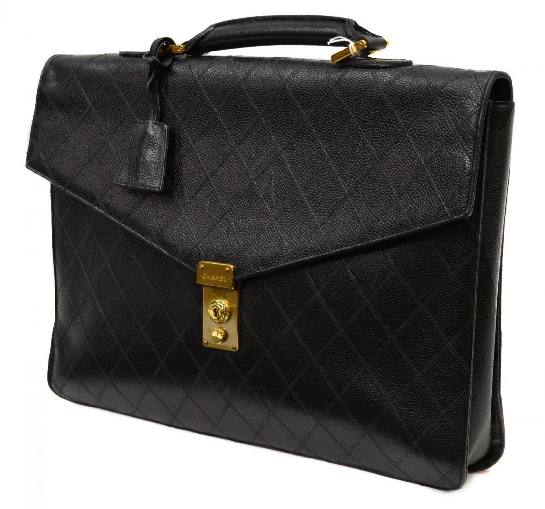 CHANEL BLACK GRAINED LEATHER BRIEFCASE: Chanel briefcase in black grain leather, black leather interior with one side zipper pocket, pen and card slot compartments, lock closure accompanied by key, wear to lock hardware, hologram sticker wo