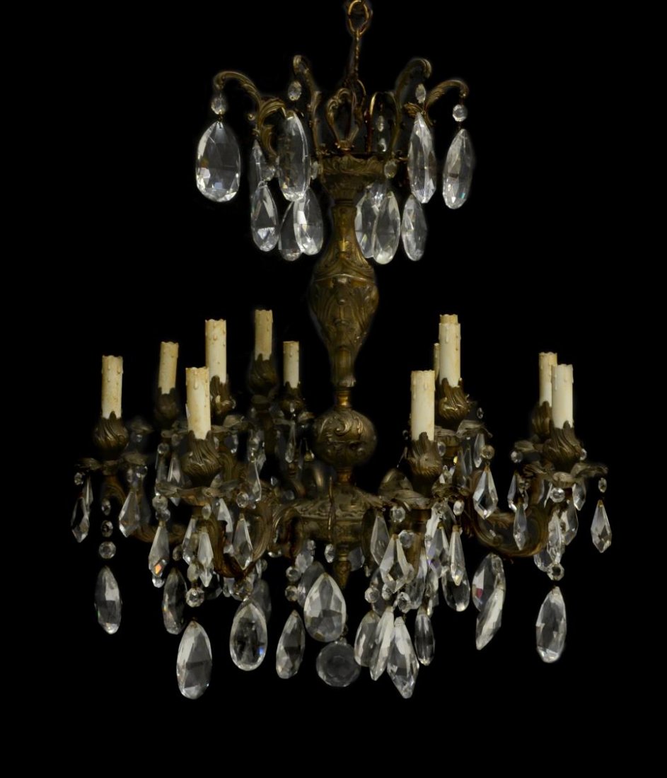ITALIAN BRONZE & CRYSTAL PRISM 12-LIGHT CHANDELIER: Italian bronze and crystal prism twelve- light chandelier, 20th c., ornate acanthus relief standard issuing twelve arms of alternating height holding flower bud form bobeches with faux candle holders 