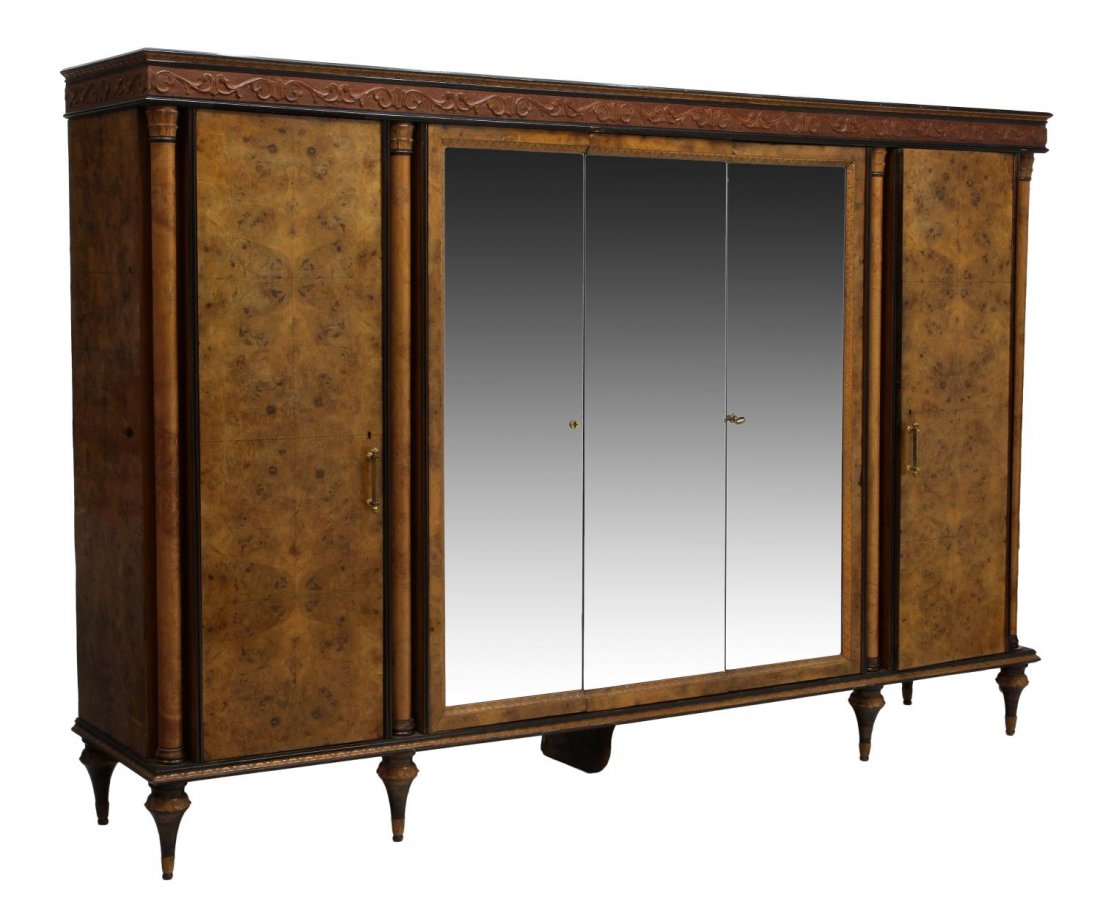 ITALIAN BAROQUE STYLE BURLWOOD MIRRORED ARMOIRE: Italian Baroque style burlwood armoire, 20th c., a stepped cornice with foliate carved frieze over three central mirrored doors opening to the interior with drawers and hanging storage, a door at each