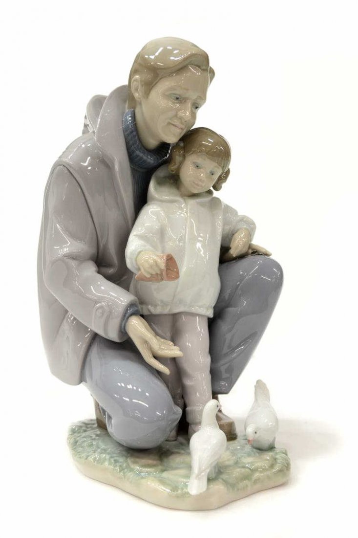 LLADRO PORCELAIN FIGURAL GROUP, A DAY WITH DAD: Lladro porcelain figural group, A Day With Dad, 6793, by sculptor Jose Luis Alvarez, issued 2001, retired 2011, father and young daughter together feeding doves, marked and incised on base, approx 10.
