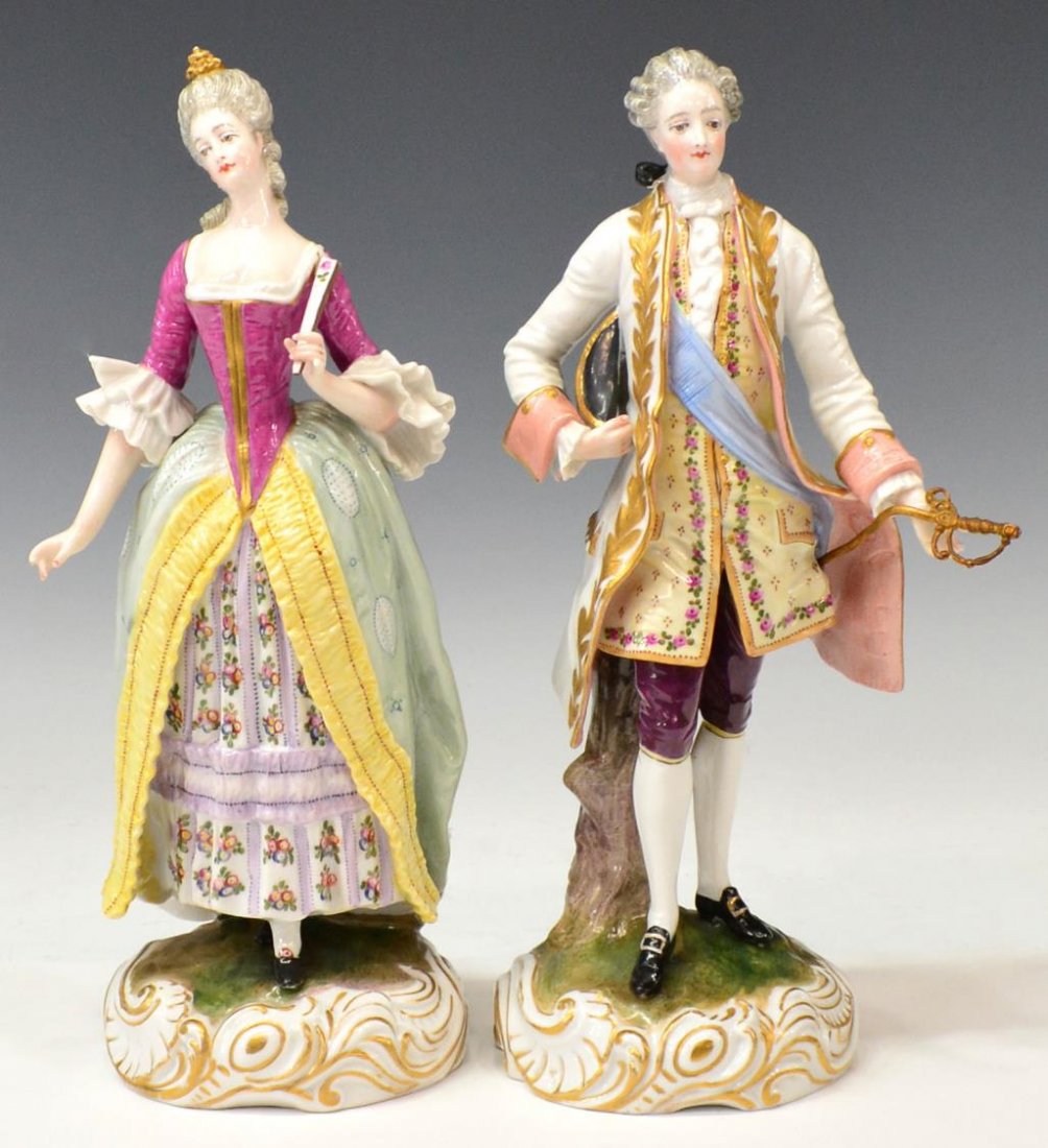 (2) MEISSEN STYLE PORCELAIN ELABORATE GENT & LADY: (pair) Meissen style porcelain figures, both standing on a naturalistic rocaille base, blue crossed sword mark as pictured: (1) gentleman wearing a parcel gilt white overcoat and breeches, holding a t