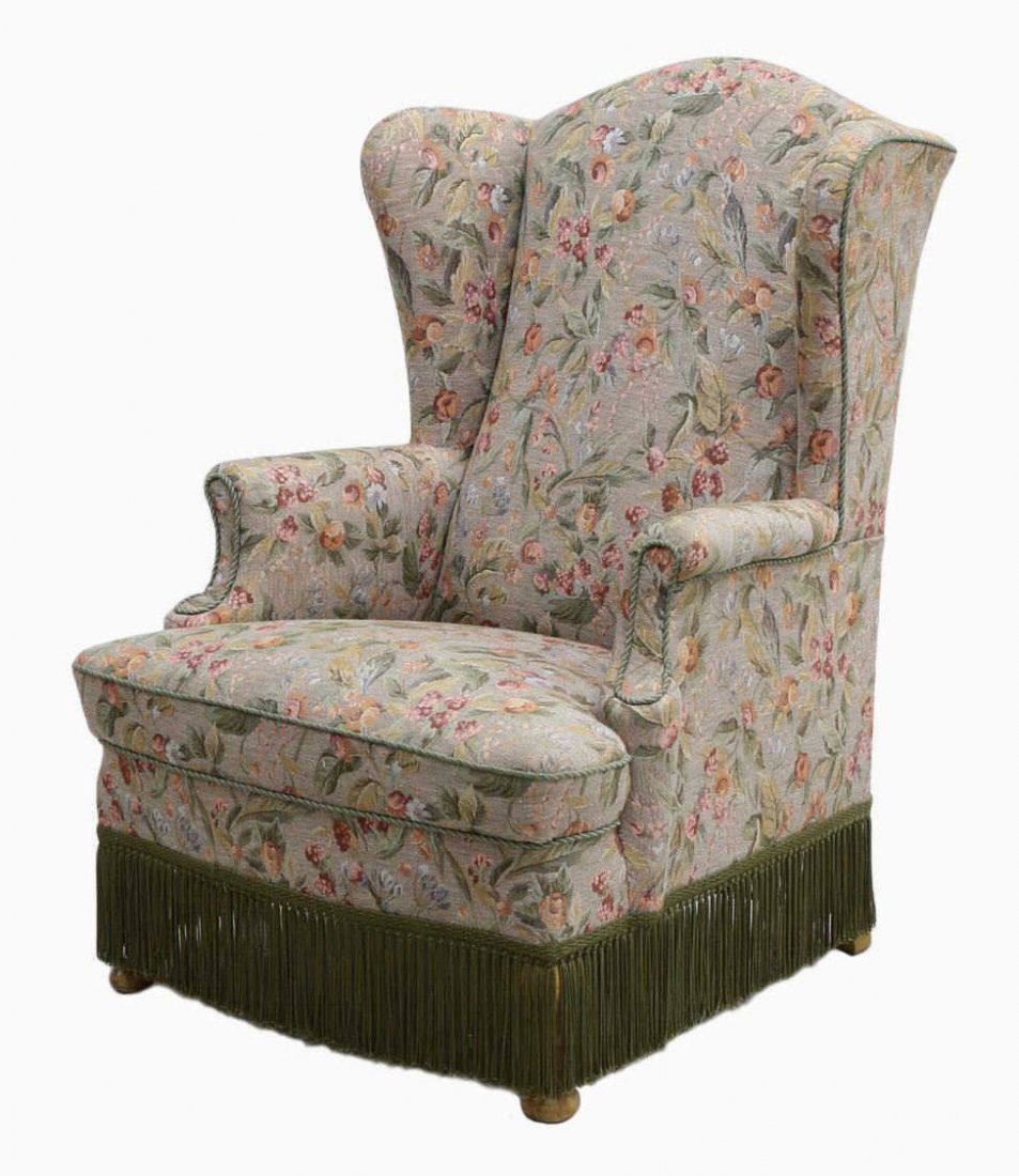 DANISH QUEEN ANNE STYLE UPHOLSTERED WINGBACK CHAIR: Danish Queen Anne style wingback chair in later floral tapestry-like upholstery, featuring gray/green rope trim and a dark green tassel skirt concealing short cabriole legs with pad forefeet, approx 4