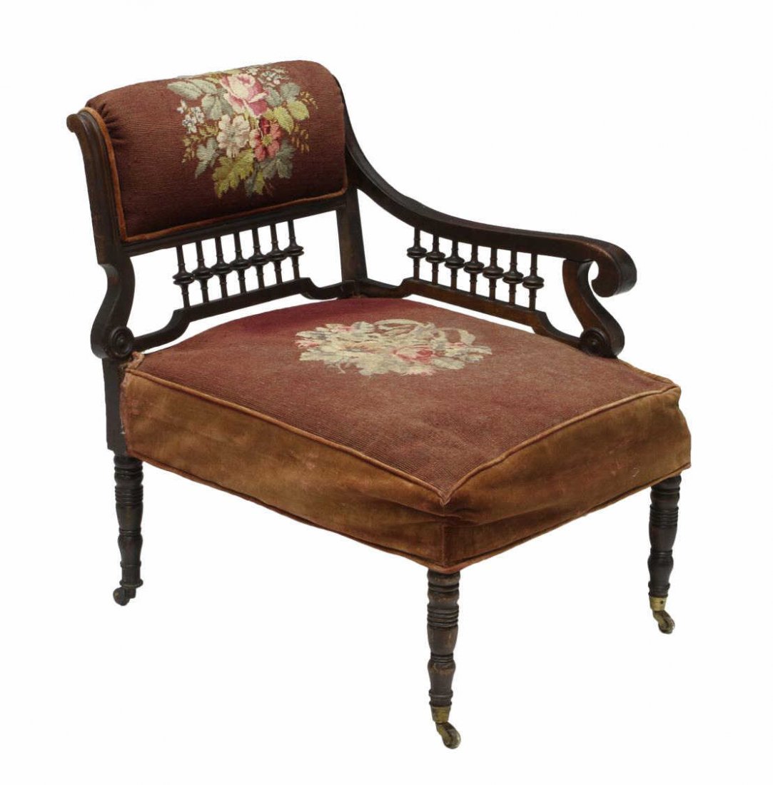 VICTORIAN NEEDLE POINT PHOTOGRAPHERS CHAIR: Late Victorian bustle chair, the needlepoint upholstered roll over top rail above the spindle galleried back and scroll carved arm, rising on three turned supports, one shaped support, all ending in c