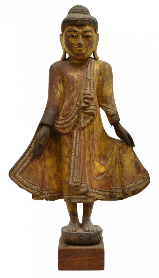 LARGE ANTIQUE STANDING THAI FIGURE OF BUDDHA: Thai giltwood standing Buddha figure, a serene expression with right hand in a varada mudra pose standing on a lotus pedestal with a square base, glass eye insert and color mirror embellishments, appr