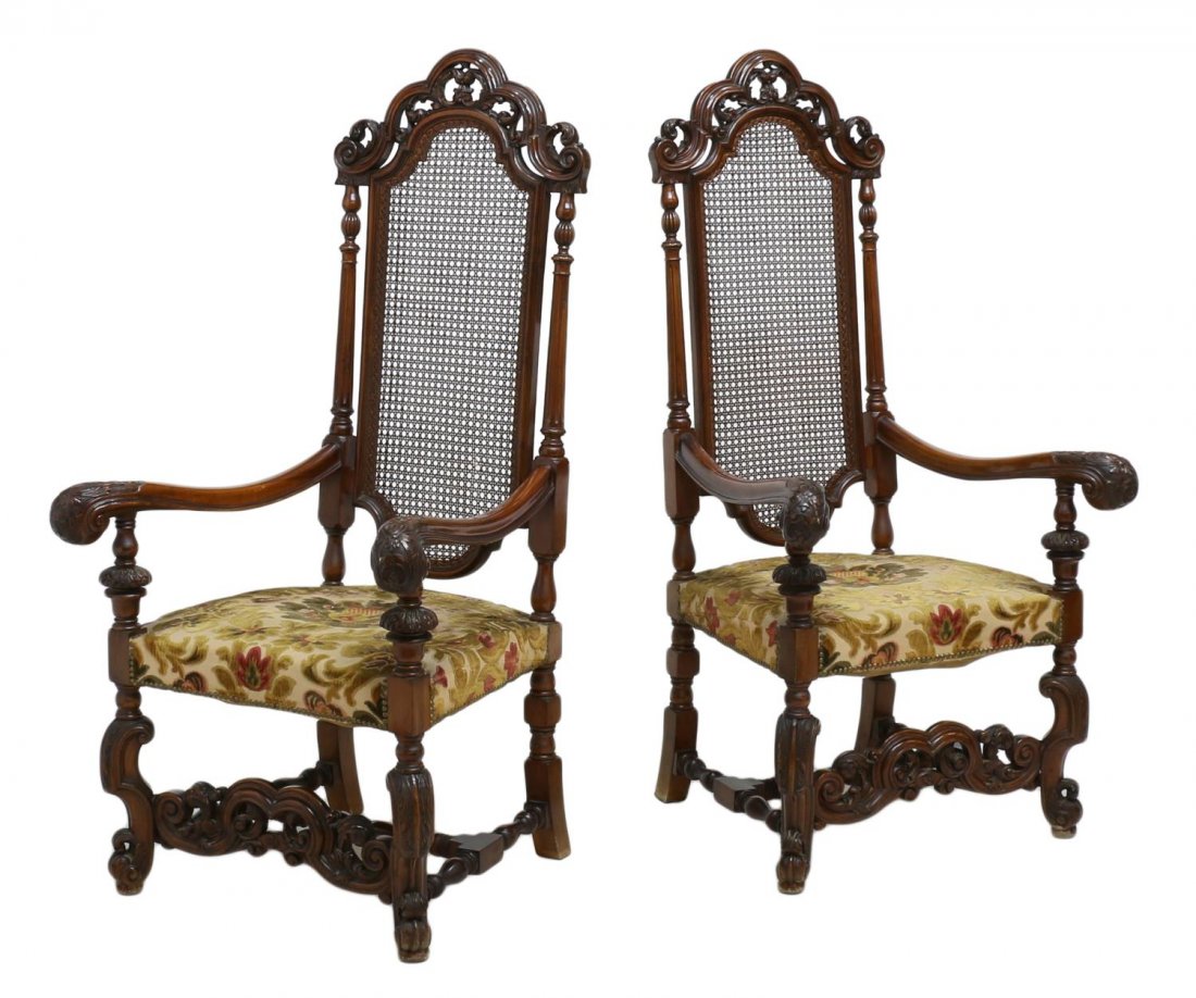 (2) SPANISH BAROQUE STYLE CANED HIGHBACK CHAIRS: (pair) Spanish Baroque style high back arm chairs, scalloped top rail with a pierced scroll carved crest, over caned splat, shaped arms with heavily carved knuckles, multicolored floral upholstered se