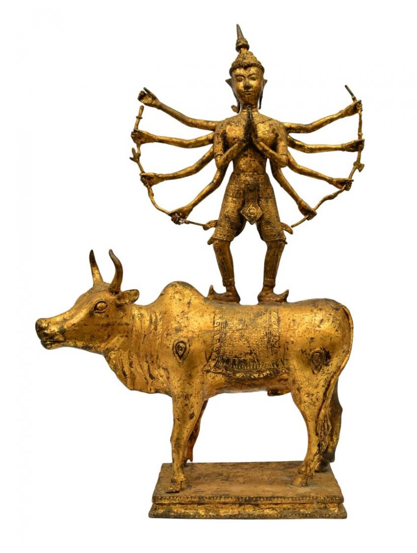 ANTIQUE THAI GILT BRONZE MULTI-ARMED DIETY ON BULL: Antique Thai / Hindu gilded bronze diety, multi-armed holding weapons including a trident, an axe, etc., standing on a bull, all raised on a rectangular plinth base, approx 30"h, 19.75"w, 35.5lbs tota