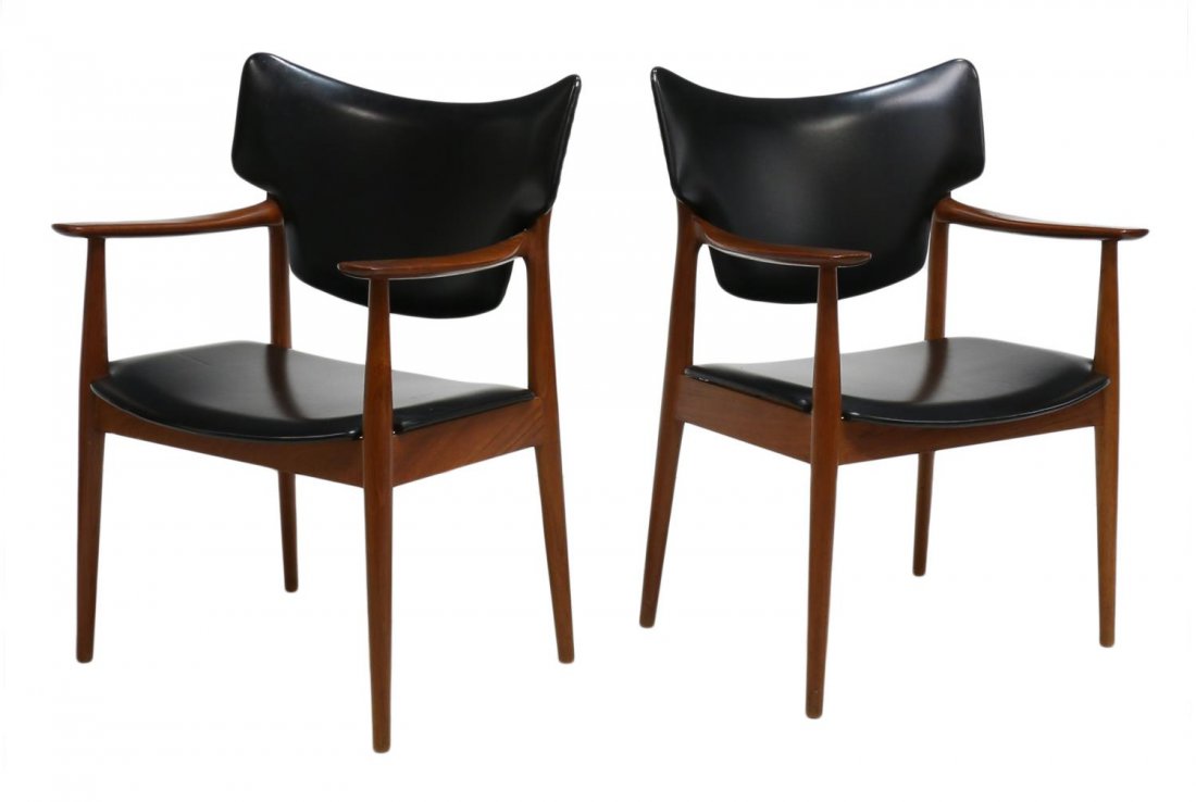(2) MID-CENTURY MODERN PETER WESSEL ARM CHAIRS: (lot of 2) Norwegian mid-century modern teakwood framed chairs, Peter Wessel Furniture Company, the shaped concave back and seat covered in black vinyl, flanking shaped arms, rising on tapered turned