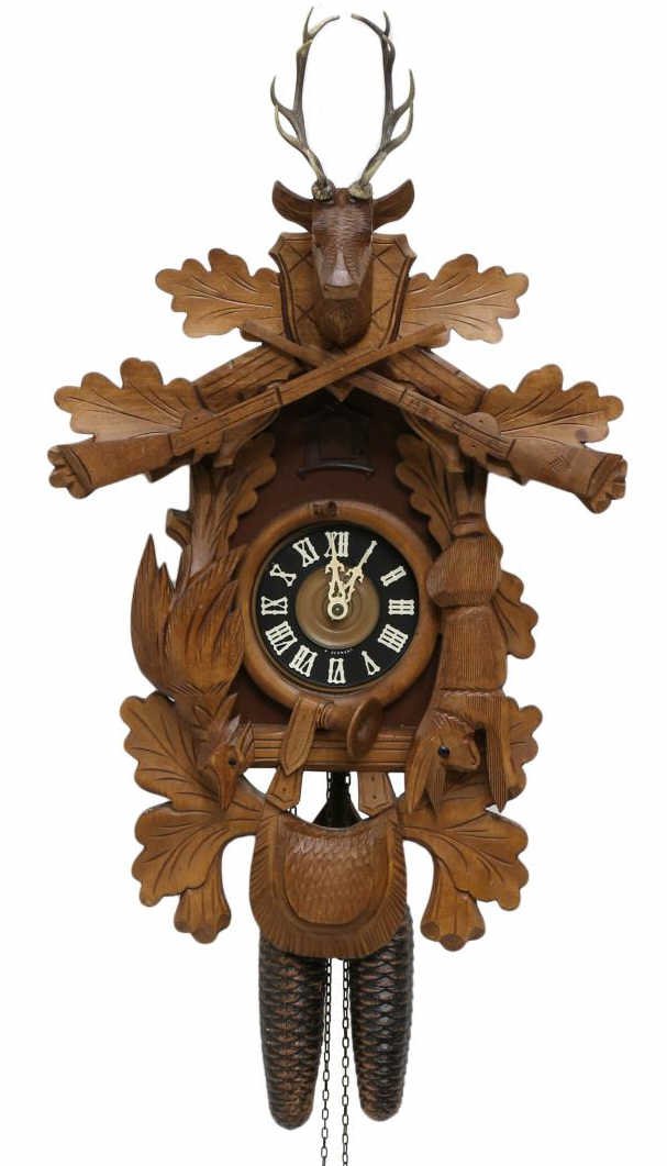 WESTERN GERMANY STAG & GAME CARVED CUCKOO CLOCK: Black Forest style eight day cuckoo clock, Western Germany, well carved deer, rabbit and pheasant on the case enclosing a black dial with white Roman numerals, approx 20.5"h, 14"w, 6.5"d, 9.75lbs tota