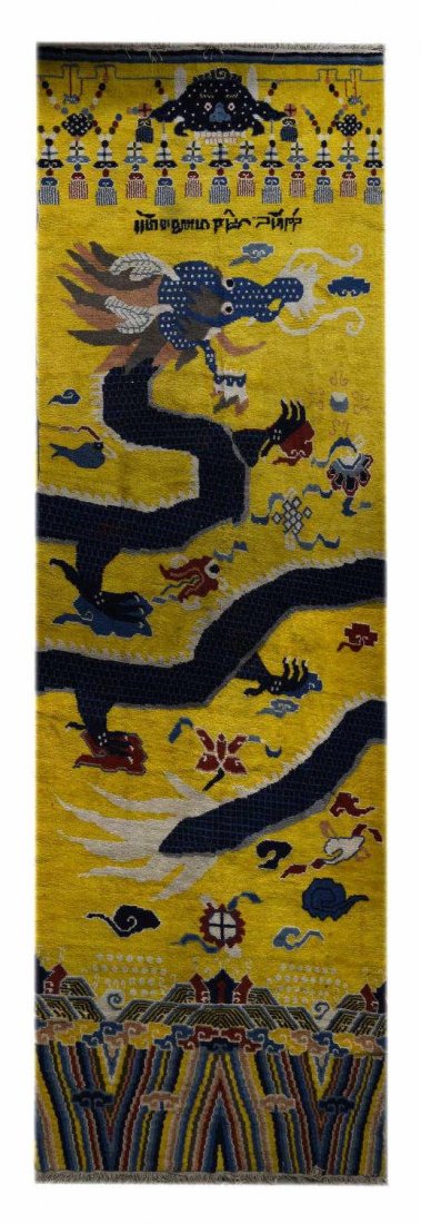 HAND TIED TIBETAN DRAGON RUG: Tibetan hand tied wool rug, a blue dragon with cloud motif on a yellow ground, inscription to the top, approx 14'7"l, 4'9"w Start Price: $2000.00