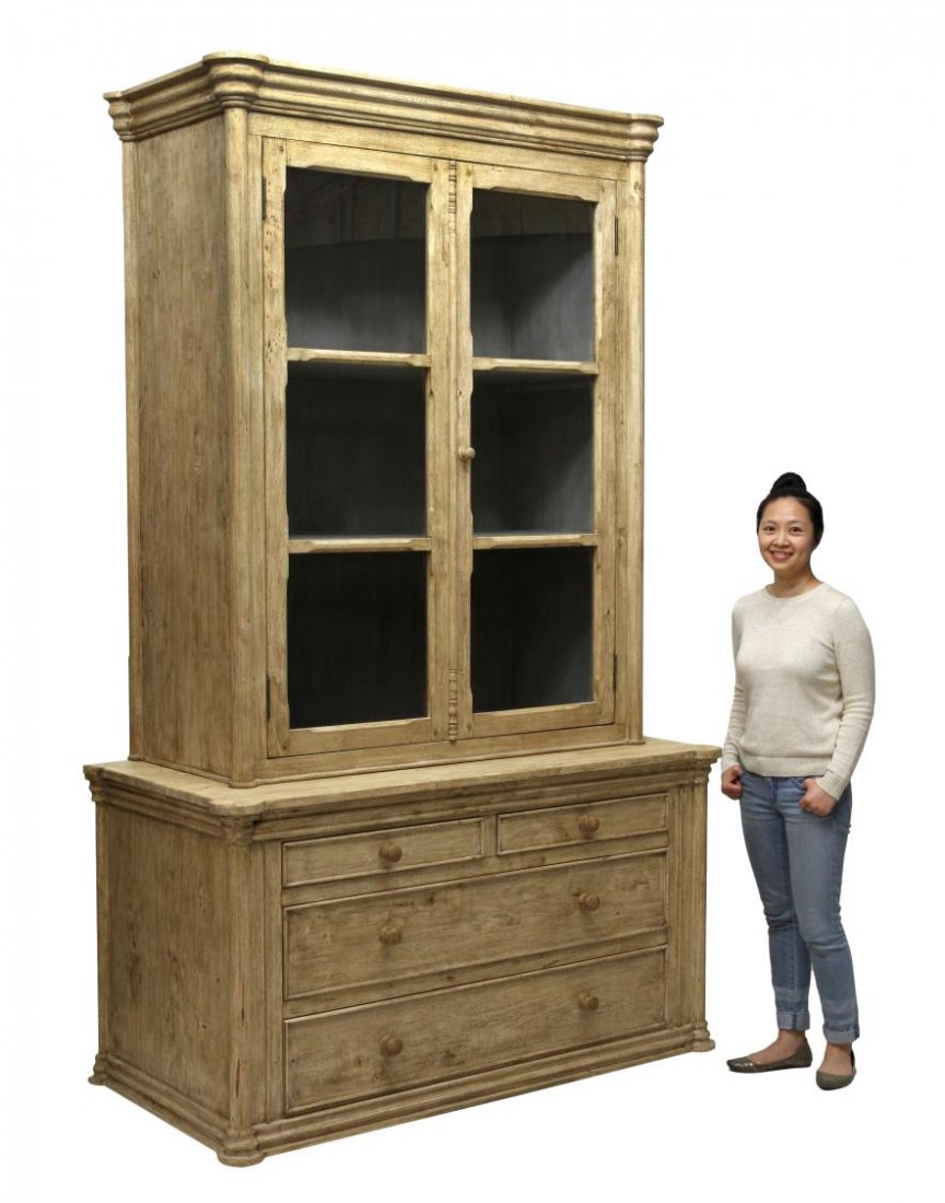 LARGE TWO PART GLASS DOOR CUPBOARD: Large two part cupboard flanked at each side by half columns, the upper part with a stepped cornice over two doors with glass panes opening to shelves, the lower part with two short drawers over two l