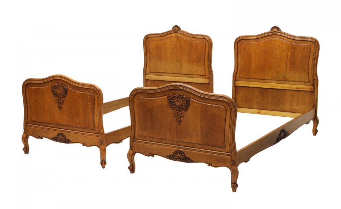 (2) LOUIS XV STYLE CARVED OAK SINGLE BEDS: (pair) Louis XV style oak single beds, each headboard having carved shell motif to center, side rails with rocaille relief, 46.25"h, 80.25"l, 39"w, inside: 77.25"l, 36"w Start Price: $100.00