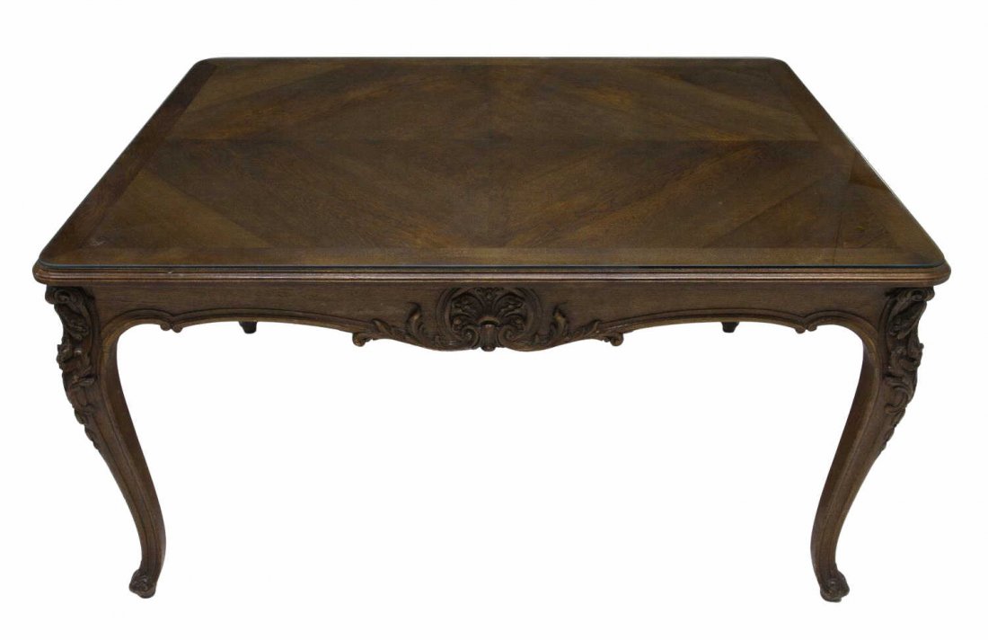 LOUIS XV STYLE CARVED PARQUETRY DINING TABLE: Louis XV style dining table, having rectangular parquetry inlaid top with rounded corners, over a serpentine foliate carved apron, cabriole legs with scroll and bellflower knees, ending in scrolled to
