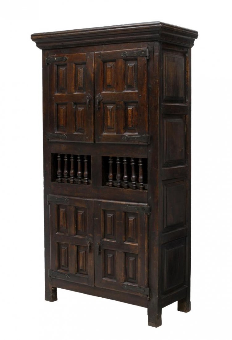 SPANISH BAROQUE PANELED CABINET: Spanish Baroque cabinet, 18th c. elements with later restoration, a stepped cornice over two iron hinged paneled doors, an open center area with spindles, two similar lower doors, rising on block feet