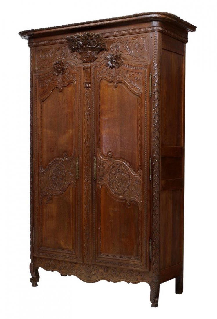 FRENCH LOUIS XV STYLE CARVED MARRIAGE ARMOIRE: French Louis XV style oak marriage armoire, 19th c., a stepped cornice over the carved frieze with a protruding floral basket, two carved paneled doors, all rising on scroll foot cabriole legs, 96"h, 