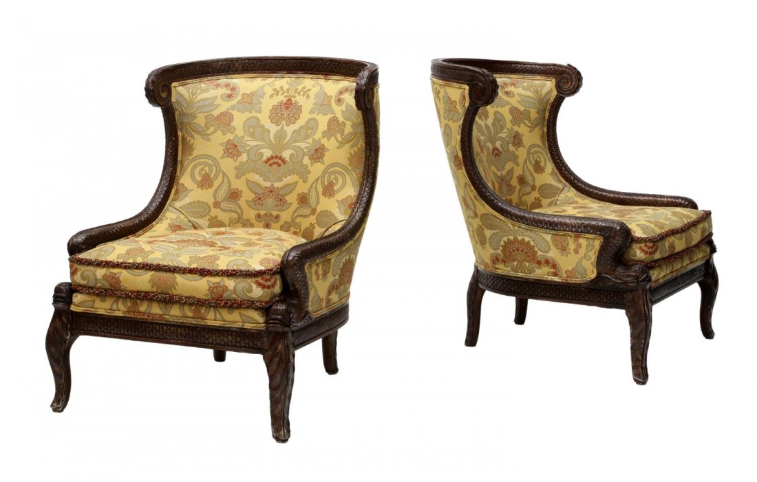 (2) EMPIRE DOLPHIN ACCENTED WINGBACK CHAIRS: (lot of 2) Empire style wingback chairs, late 20th c., each framed in running Dolphin scale carving terminating in dolphin heads, foliate patterned fabric with removable cushion, rising on carved legs
