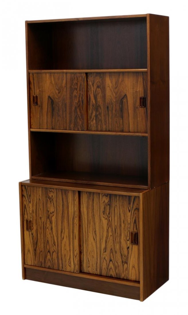 DANISH MID-CENTURY MODERN ROSEWOOD BOOKCASE: Danish mid-century modern rosewood bookcase, c. 1950's / 1960's, open shelving on the upper section, centers sliding doors opening to a shelf, on a conforming cabinet base, approx 66.75"h, 25"w, 16.75