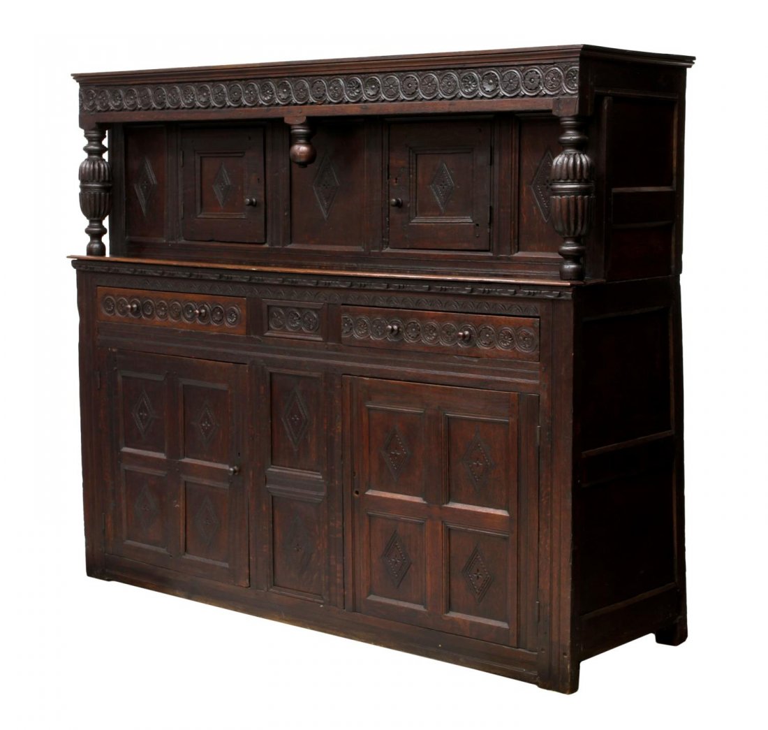 ENGLISH 17TH C. COURT CUPBOARD: English oak court cupboard, 17th c., the upper part with bulbous supports and a stepped cornice over the geometrically carved frieze, two paneled doors, an open work surface over two frieze drawers an