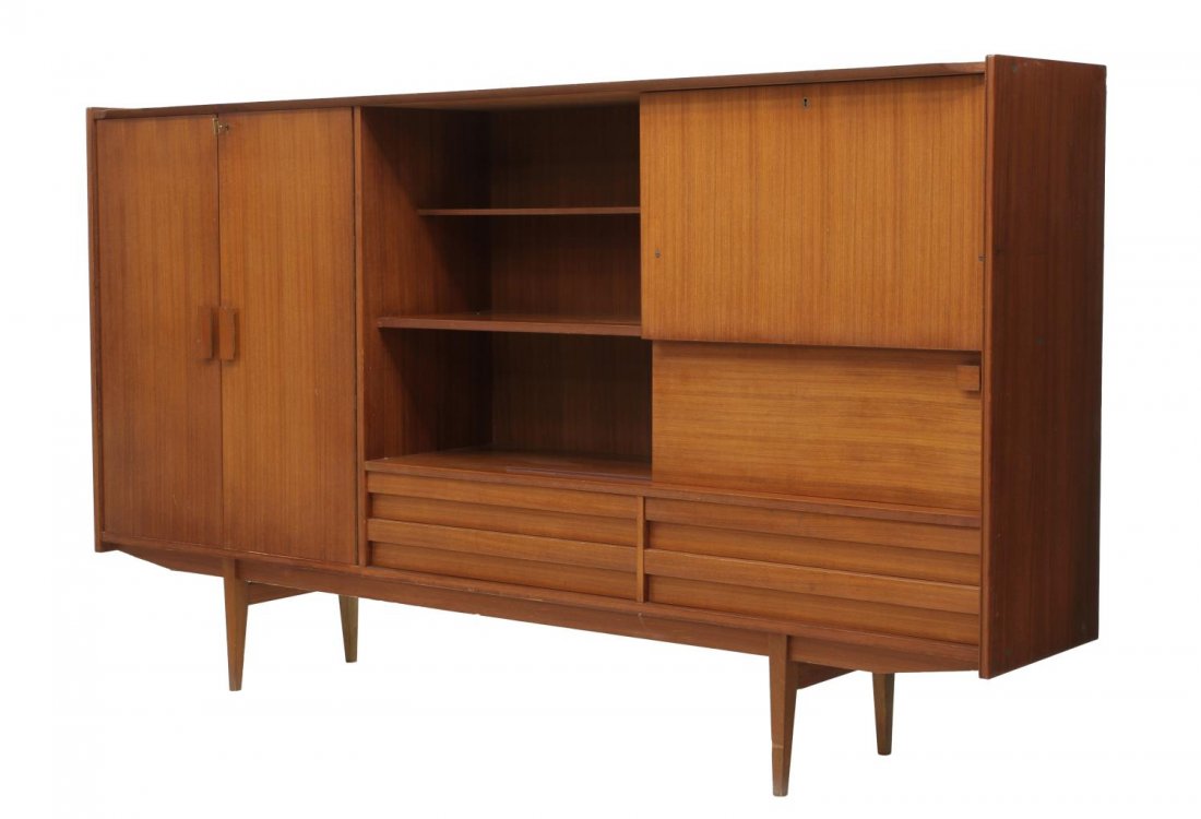 LARGE MID-CENTURY MODERN TEAKWOOD SIDEBOARD: Large teakwood mid-century modern sideboard, 1960's, rectangular central shelves flanked at one side by two doors, the other side by a drop front writing surface, a central sliding door and four lower