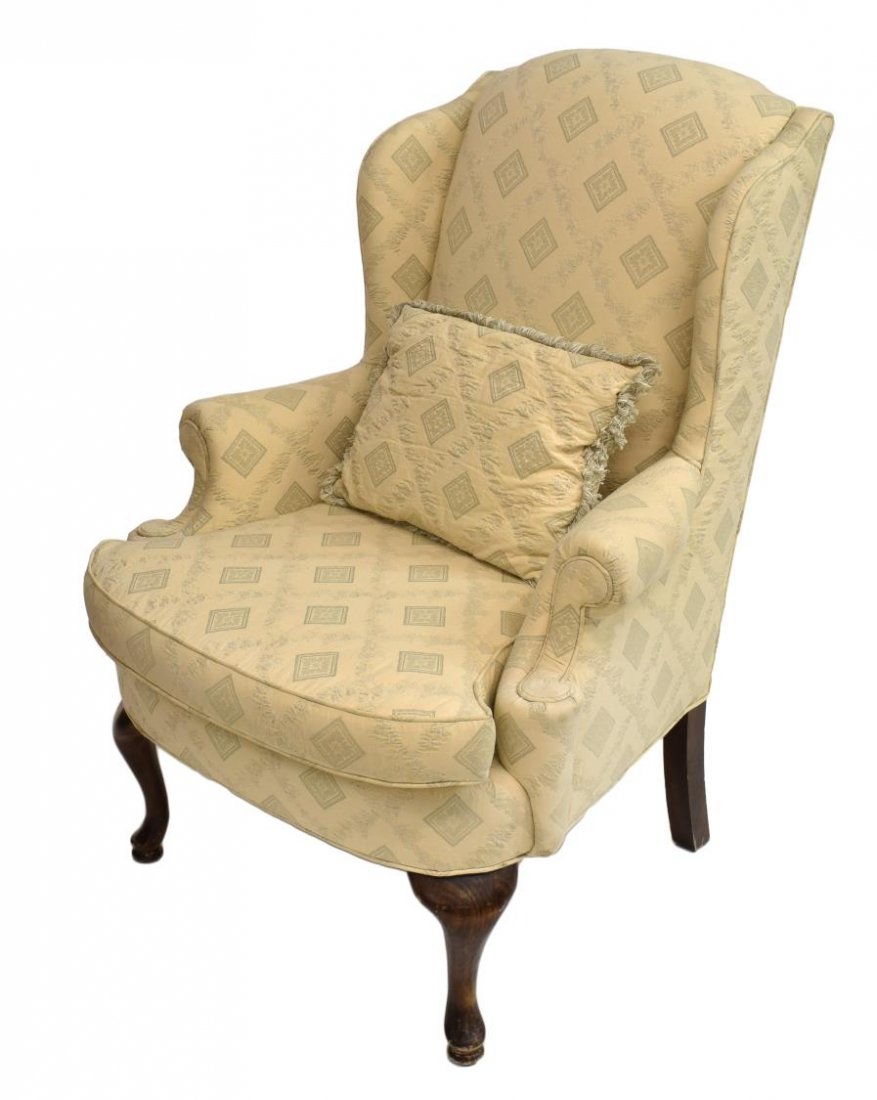 QUEEN ANNE STYLE UPHOLSTERED WING BACK CHAIR: Queen Anne style wingback chair, having cream woven upholstery, with matching pillow, rising on walnut legs, 44"h, 24"w, 35"d Start Price: $80.00