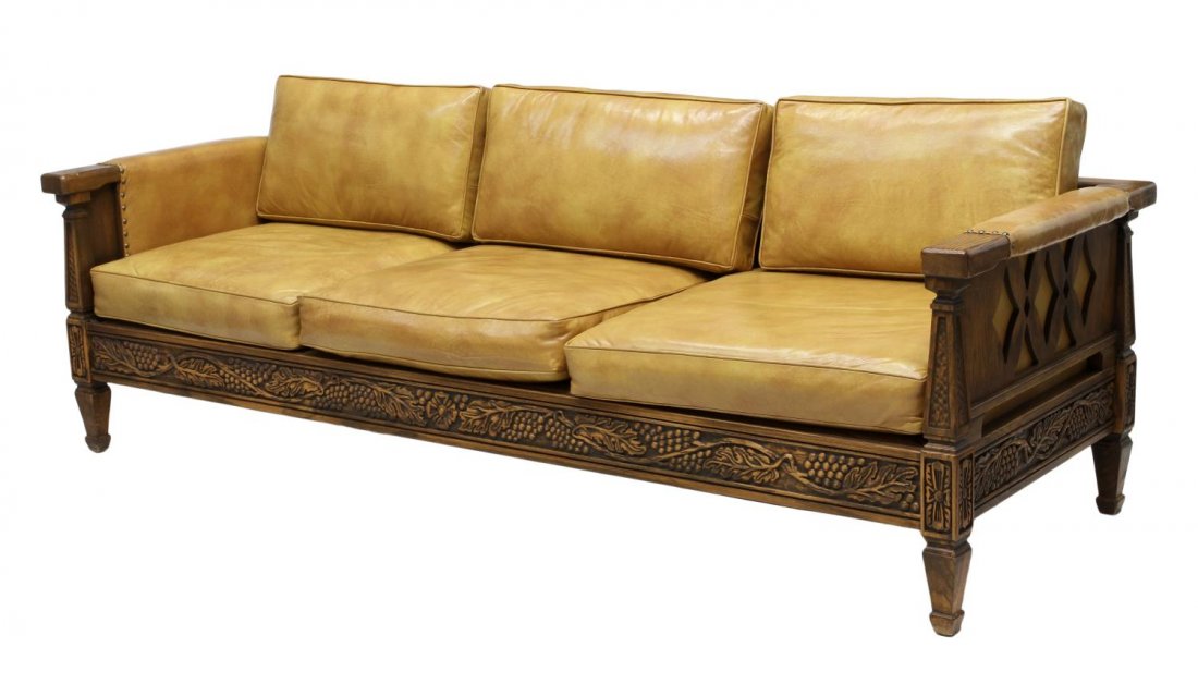 ROMWEBER OAK FRAMED LEATHER UPHOLSTERED SOFA: Vintage Romweber oak and leather sofa, Batesville, Indiana, c. 1978, carved with trailing grapevines, tan leather upholstery with loose cushions, raised on tapered square legs, retaining makers tag at