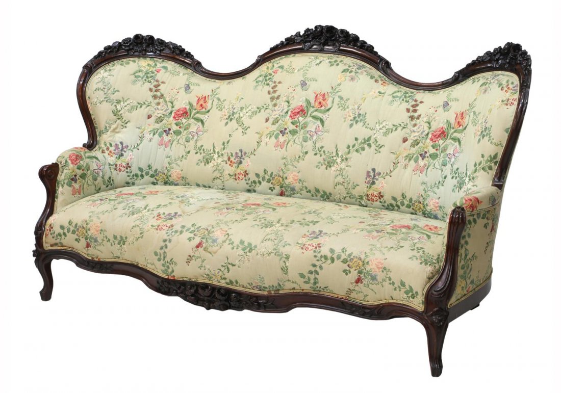 AMERICAN VICTORIAN ROCOCO REVIVAL ROSEWOOD SOFA: American Victorian Rococo Revival rosewood sofa, the serpentine crested by well carved floral sprays, joined to padded arm rests, worn upholstery, rising on short cabriole legs, approx 40.5"h, 77.75"w