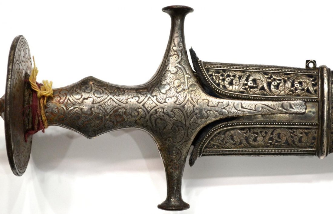 INDO-PERSIAN TALWAR SILVER OVERLAY SWORD: Indo-Persian Mughal Talwar sword with sheath, early 19th c., curved 31" blade, silver overlaid 8" handle, worn functional blue fabric covered wood sheath having a reticulated silver throat with foliat