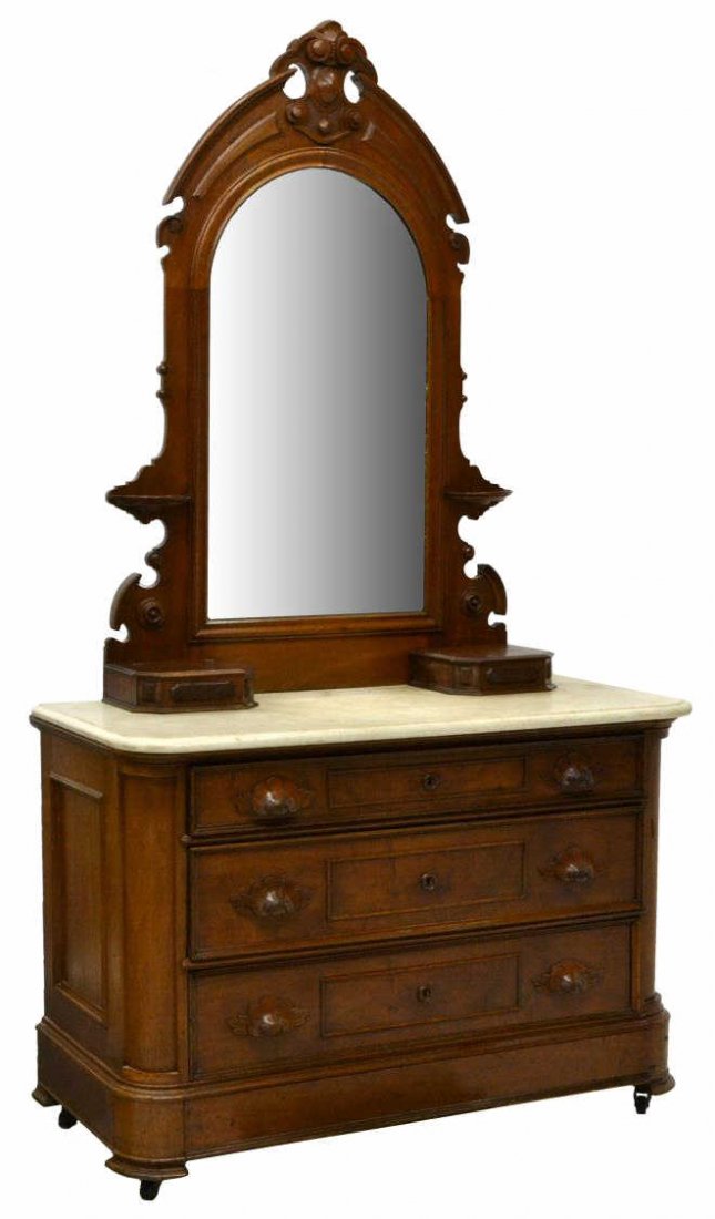 AMERICAN RENAISSANCE REVIVAL MARBLE DRESSER: American Renaissance Revival walnut dresser, 19th c., a carved crest surmounting a pair of candle shelves on either side of the rectangular mirror, two glove boxes rest on the white marble top, over s