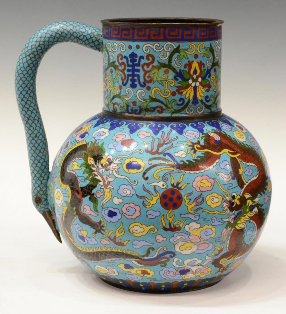 ANTIQUE CHINESE CLOISONNE DRAGON PITCHER: Antique Chinese cloisonne pitcher, neck decorated with extensive geometric and floral patterns, handle modeled as bird head, body decorated with dragons and clouds, minor enamel loss to handle, paint