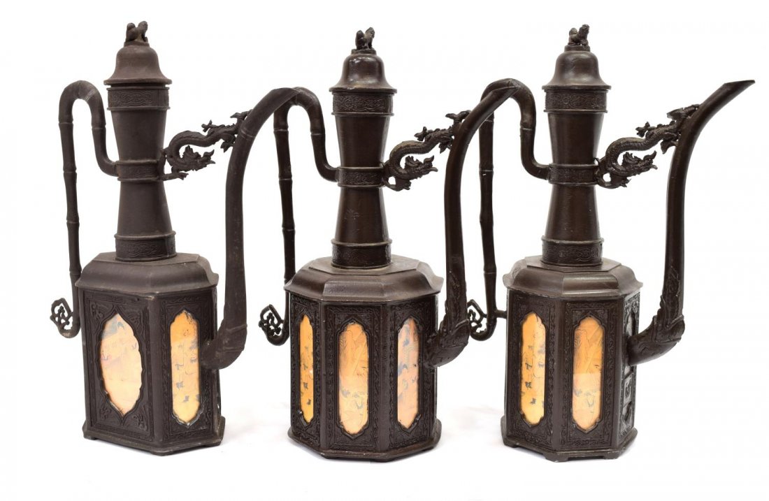 (3) ASIAN DECORATIVE BRONZE LIDDED PITCHERS 20TH C: (3) Asian decorative bronze urn pitchers, 20th c., each having a lid with a fu dog finial above a banded neck, faux bamboo handle, spout accented with dragon form bracket, above a multi-sided body, sh