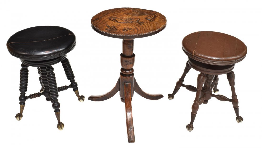 (3) AMERICAN CARVED PIANO STOOLS & OAK TABLE: (lot of 3) American ball and claw piano stools and carved table, comprising: (2) piano stools, 19th c., each with rotating seats over four ribbed legs, metal claw feet grasping glass balls, largest: 1