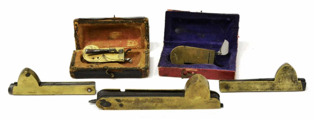 (5) CIVIL WAR ERA FLEAMS, TWO SPRING FLEAMS IN BOX: (lot of 5) Fleam tools: (1) foliate engraved brass housed in leather case with illegible makers name at top of case; (1) brass and steel fleam in red box; (1) brass pocket fleam, three blades, marked 
