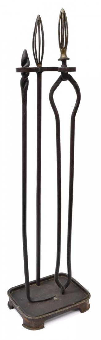 (3) ANTIQUE CAST IRON FIREPLACE TOOL SET: (lot of 3) Antique cast iron fireplace tool set, comprising: (1) stand with pierced fin, above stroll form arms and rectangular base; (1) tongs with pierced finial; (1) twist top log poker; 38"h, 9"w,