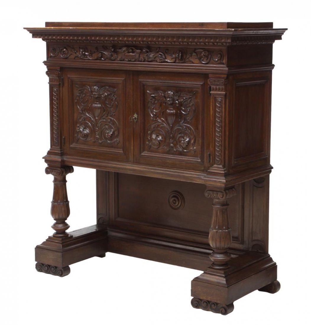 ITALIAN RENAISSANCE REVIVAL CARVED CABINET: Italian Renaissance Revival cabinet, 19th c., a protruding cornice over the foliate, griffin and winged putti carved front with two doors, rising on columnar legs from the open base with volute feet, 