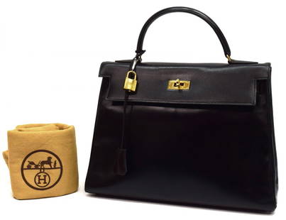 HERMES BLACK LEATHER KELLY RETOURNE 32 HANDBAG: Hermes "Kelly Retourne 32" black leather handbag, single handle over gilt metal hardware, turn lock, lock, keys in clochette, and dust bag, 2lbs Start Price: $2500.00