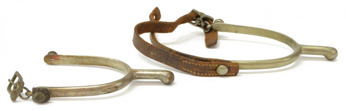 U.S. CAVALRY M1911 SPURS, AUGUST BUERMANN: (pair) U.S. Cavalry Model 1911 spurs, both marked at interior heel band "U.S." over A.B. (August Buermann Co.), one with leather, approx. 5"l, 2.75" widest inside, .25lb Start Price: $40.00