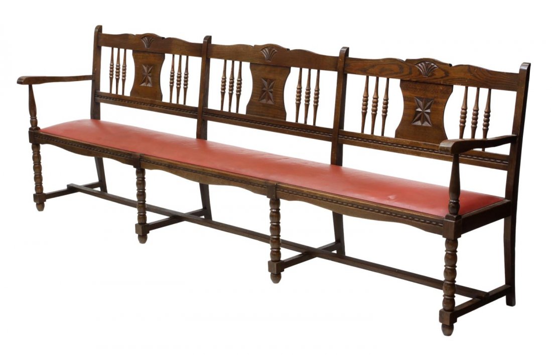 COUNTRY FRENCH LONG BENCH, SETTEE: French Country long bench or settee, mid 20th c., having a rail back with foliate decoration, shaped arms on turned supports flanking the red vinyl upholstered seat, stretcher joined turned legs and f