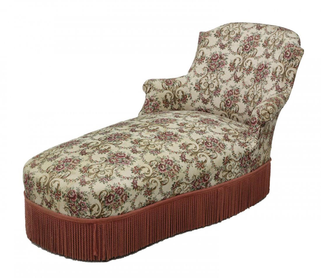 FRENCH UPHOLSTERED CHAISE LOUNGE: French chaise lounge, c. 1900., upholstered in later foliate and floral fabric with long mop fringe, rising on turned supports with castors *Provenance: Dreyfus Antiques, Austin, Texas* Start Price: $