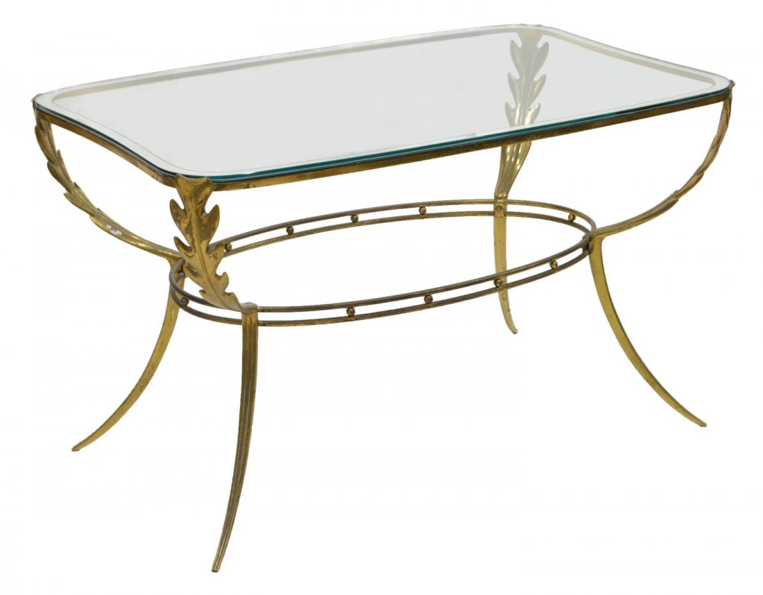 ITALIAN DESIGN GLASS & BRASS COFFEE TABLE C. 1960: Italian design glass and brass coffee table, c. 1960, the rectangular glass top above leaf form supports, over an oval stretcher, rising on fluted tapered legs, 20"h, 33"w, 20"d Start Price: $250.00