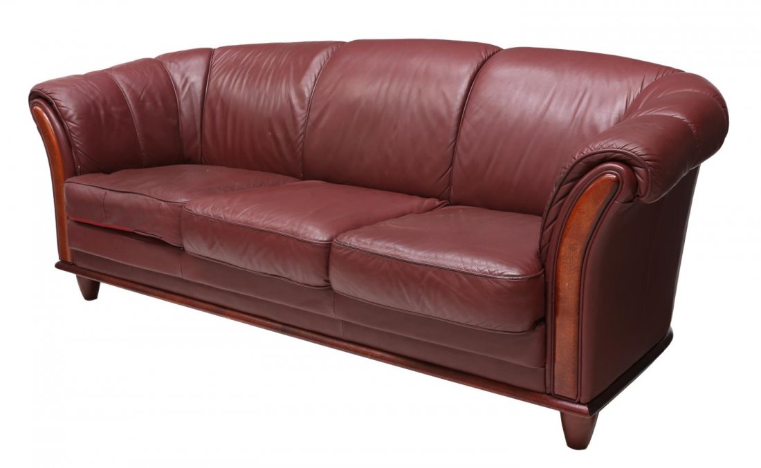 DANISH MODERN BURGUNDY LEATHER SOFA, C. 1970S: Danish modern burgundy leather sofa, c. 1970s, the curved back sloping down into the padded armrests, with cord detail, rising on short cylindrical supports, 31"h, 76"w, 33"d Start Price: $200.00