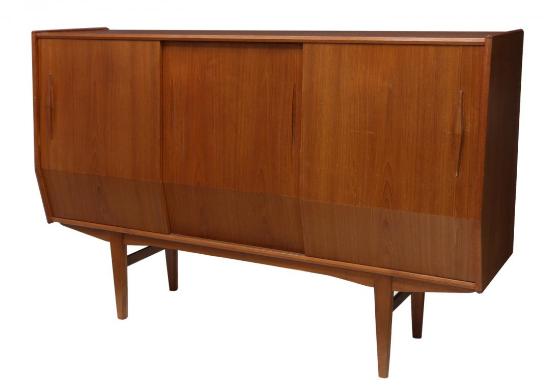 DANISH MID-CENTURY MODERN TEAKWOOD SIDEBOARD: Danish mid-century modern teakwood sideboard, the shaped case having sliding doors fitted with shelves and pull out tray drawers, rising on squared tapered legs, approx. 45.25"h, 71"w, 18.5'd Start Pr