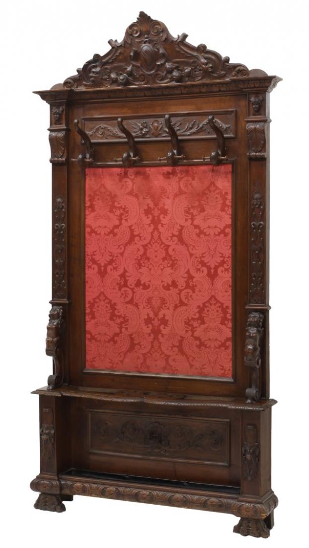 ITALIAN RENAISSANCE REVIVAL CARVED HALL TREE: Italian Renaissance Revival hall tree, late 19th c., an arched foliate and fruit carved cornice with the winged figural carved frieze over four scrolled coat hooks, the center with a red on red foliat
