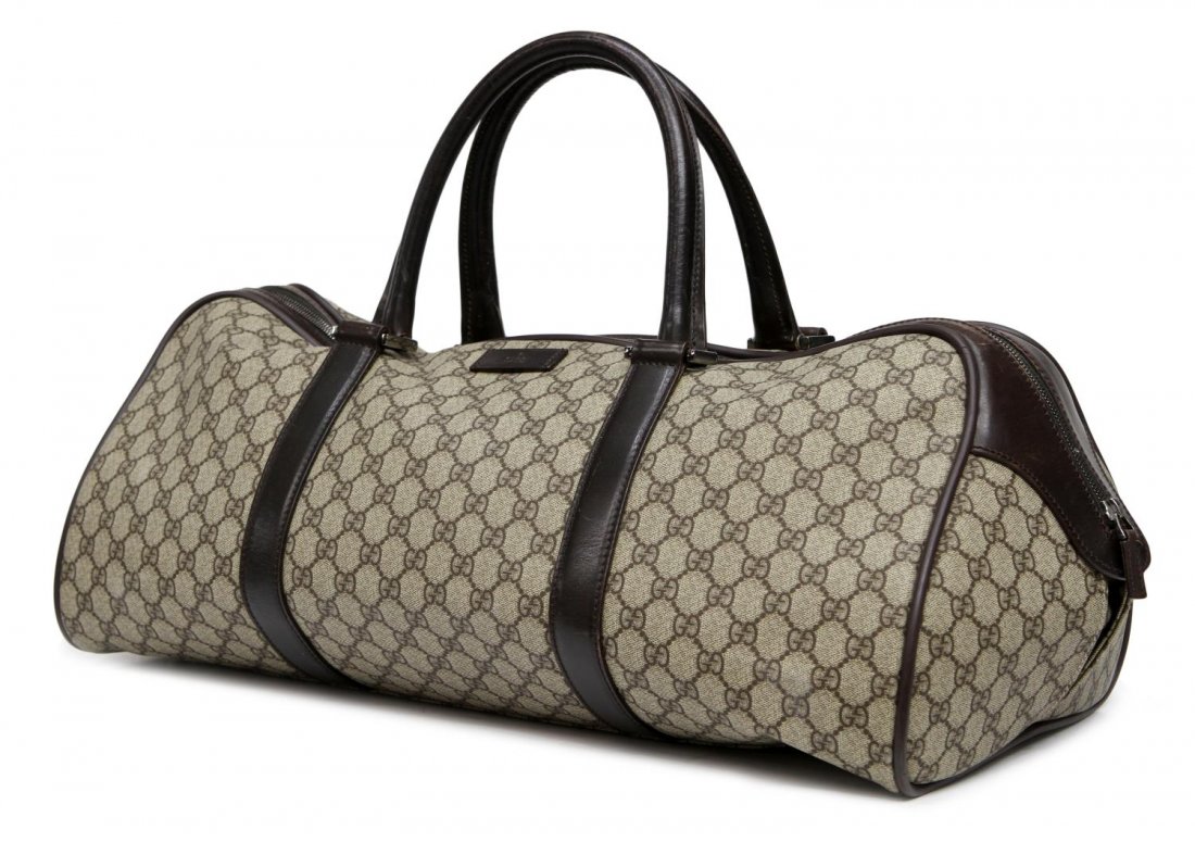 GUCCI MONOGRAM COATED CANVAS TRAVEL BAG: Gucci brown monogram coated canvas duffle travel bag, brown leather trim, black canvas interior with single zipper closure, some wear to leather, bag; approx 8.5"h, 21.5"w, 11"d, 2lbs Start Price: $20